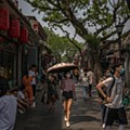 Tourists wearing protective face masks walk in Nanluoguxiang alley as China loosens up nationwide restrictions after months of lockdown..jpg